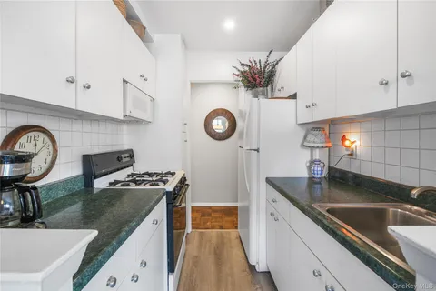 a kitchen with granite countertop a sink a stove and cabinets