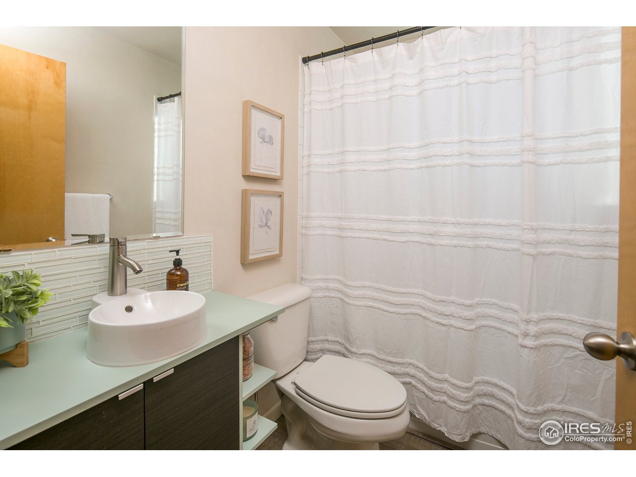 4742 16th Street Boulder, CO 80304 - Photo 22 of 38 a bathroom with a sink toilet vanity and shower