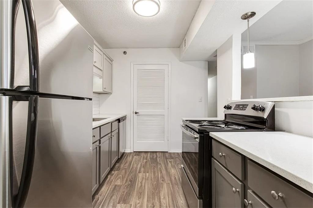 a kitchen with a refrigerator a stove and white cabinets