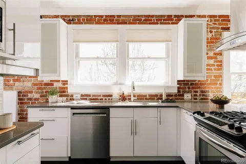 a kitchen with a sink stove top oven and cabinets