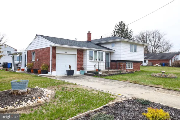 a front view of a house with a yard and trees
