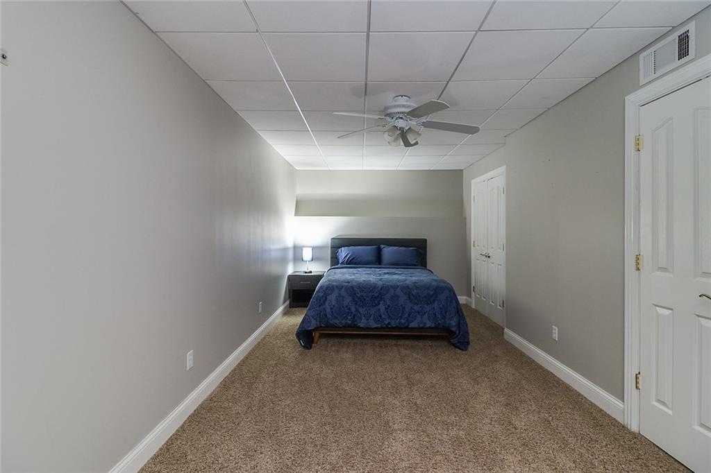 6150 Six Mile Cove Road Cumming, GA 30041 - Photo 18 of 27 a bedroom with a bed and a chandelier fan