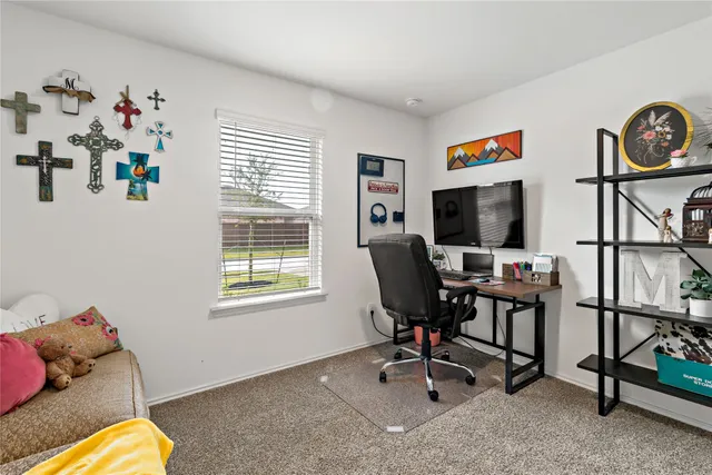 a view of a workspace with furniture and a window