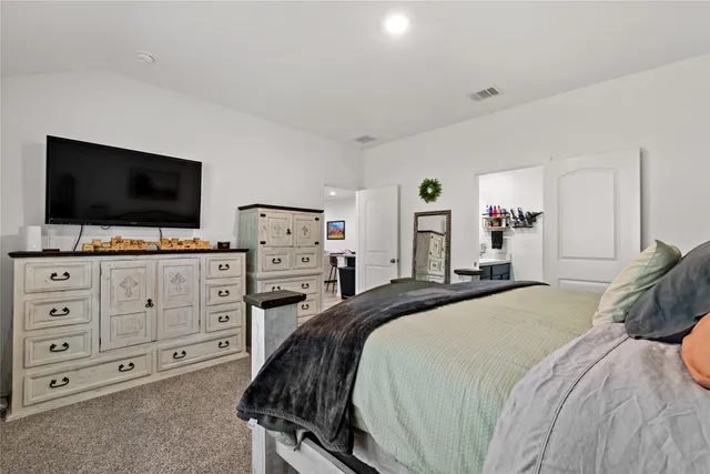 a bedroom with a bed and flat screen tv