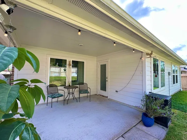 a view of a patio with chairs and plants