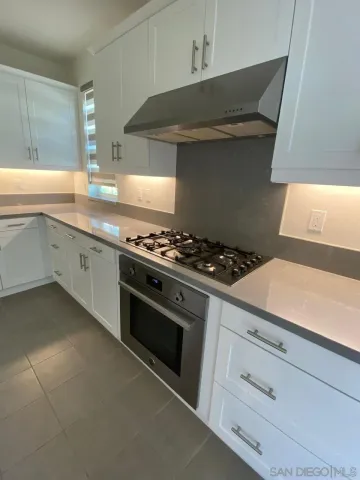 a kitchen with granite countertop a stove and a sink