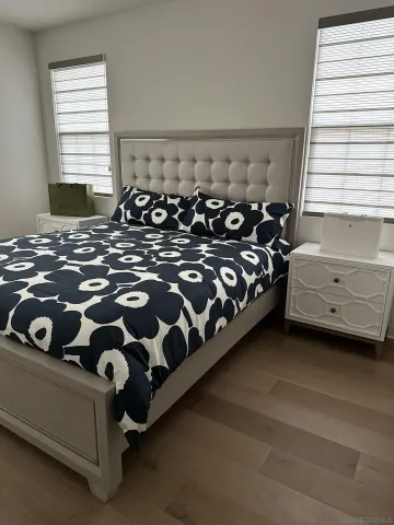 a bed sitting in a bedroom next to a window with a couch