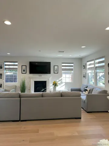 a living room with furniture a fireplace and a large window