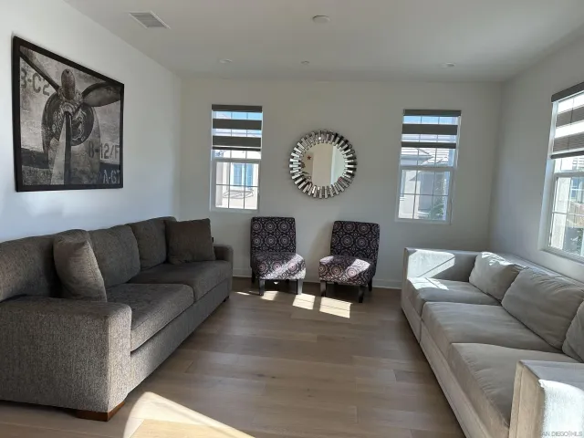 a living room with furniture a bed and a large window