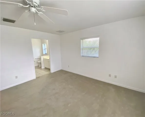 an empty room with a ceiling fan and a window