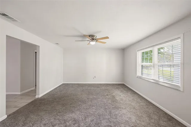 a view of a livingroom with a ceiling fan and window