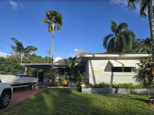 a view of a patio with table and chairs potted plants and palm tree