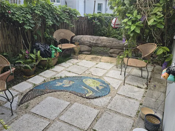 a backyard of a house with table and chairs plants