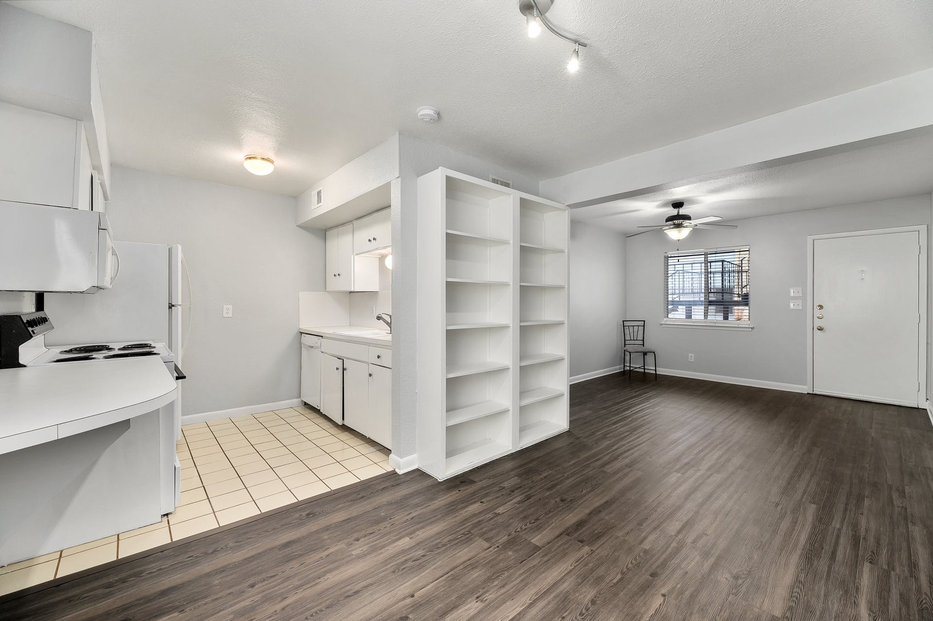 2408 Longview Street, Unit 113 Austin, TX 78705 - Photo 7 of 23 Kitchen with open shelves, light countertops, white cabinetry, white appliances, and light wood-type flooring