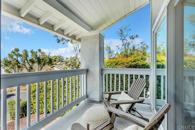 a view of a patio with chairs and table under an umbrella