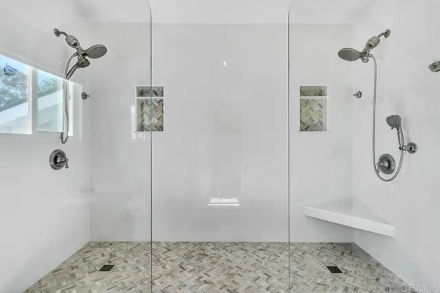 a front view of a building with glass windows and plants