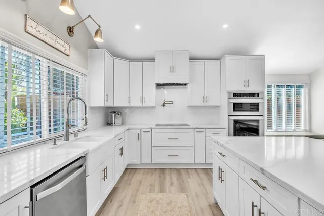 a large white kitchen with cabinets and chairs