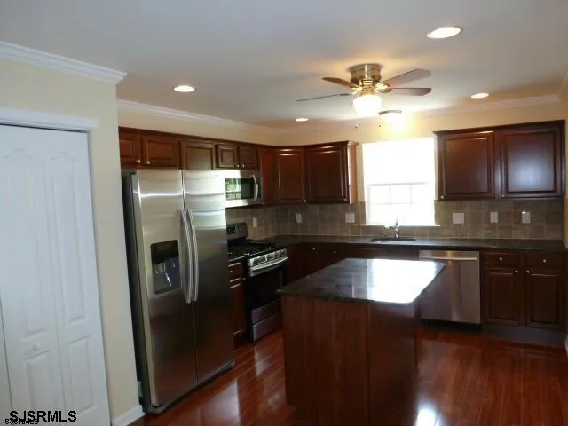 a kitchen with a refrigerator a sink and cabinets