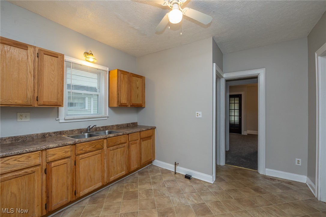 3396 Tullamore Road Cleveland, OH 44118 - Photo 10 of 23 Kitchen with dark countertops, a textured ceiling, and a ceiling fan