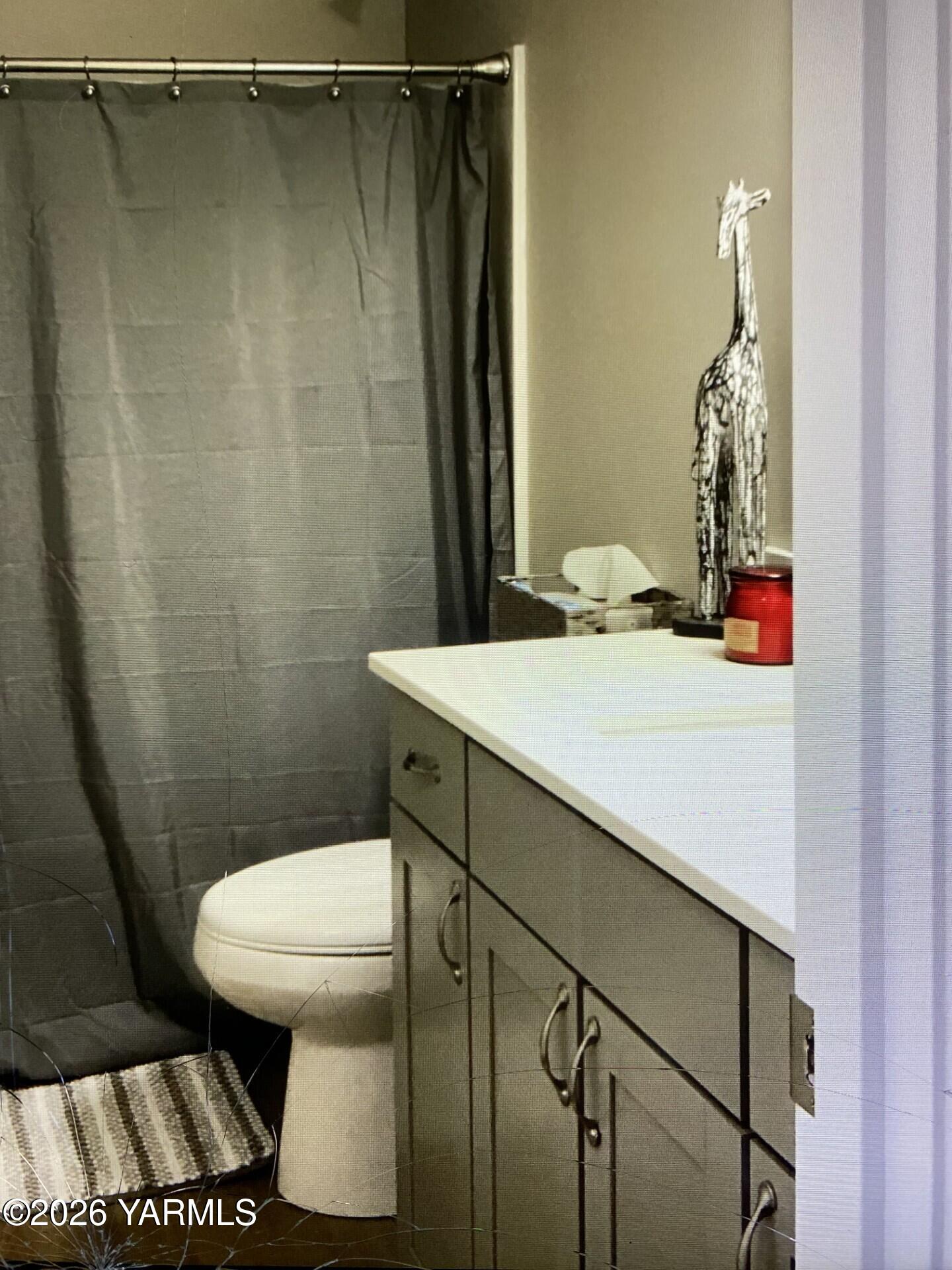 2600 Racquet Lane, Unit 36 Yakima, WA 98902 - Photo 4 of 5 a bathroom with a sink a toilet and shower curtain