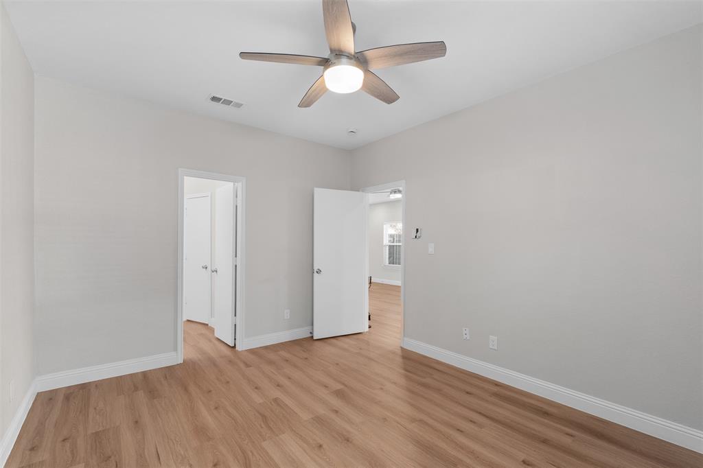 2906 Roxboro Road Euless, TX 76039 - Photo 11 of 23 an empty room with wooden floor ceiling fan and window