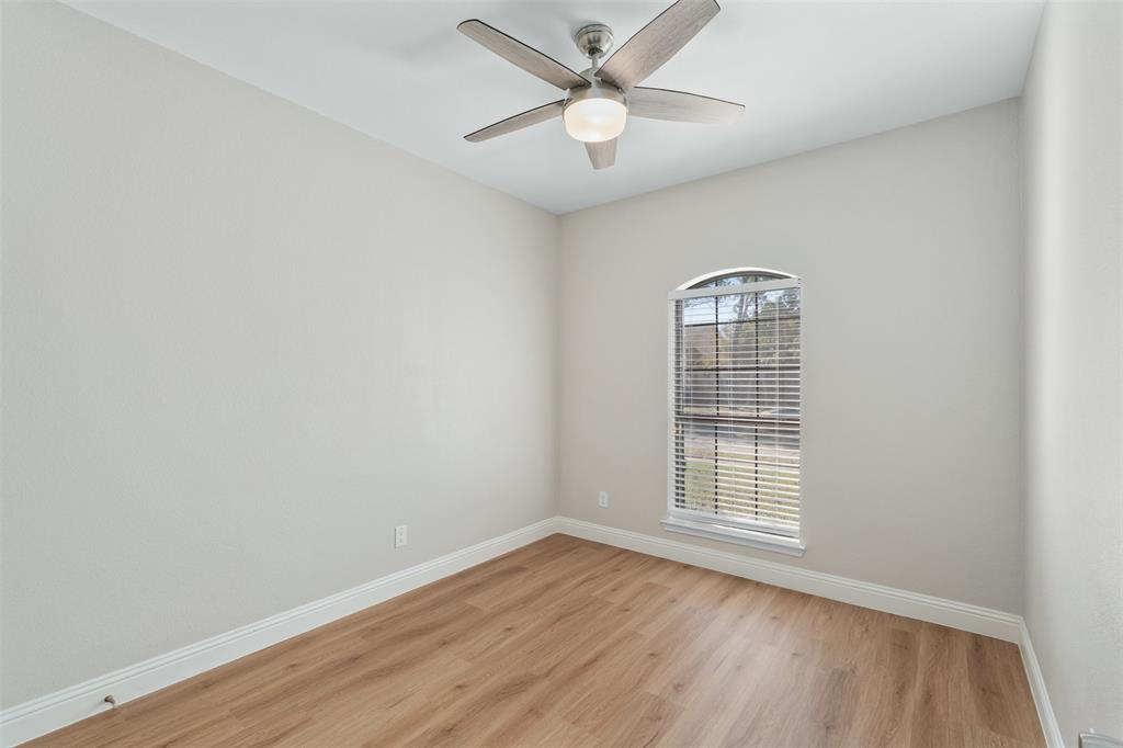 2906 Roxboro Road Euless, TX 76039 - Photo 14 of 23 an empty room with wooden floor ceiling fan and windows