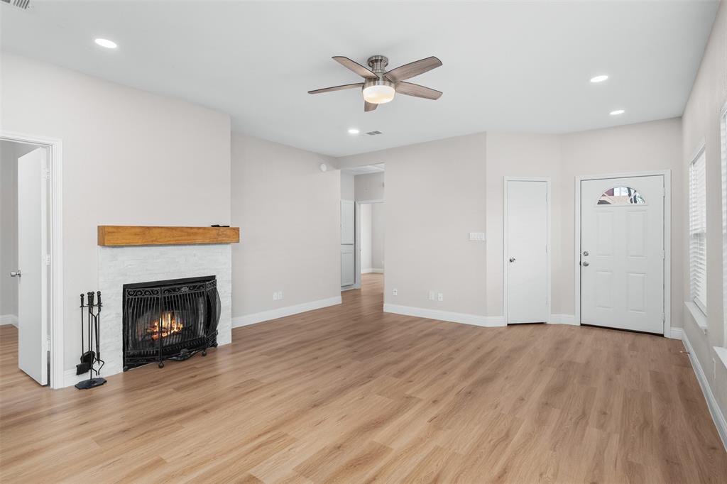 2906 Roxboro Road Euless, TX 76039 - Photo 5 of 23 a view of an empty room with wooden floor fireplace and a window