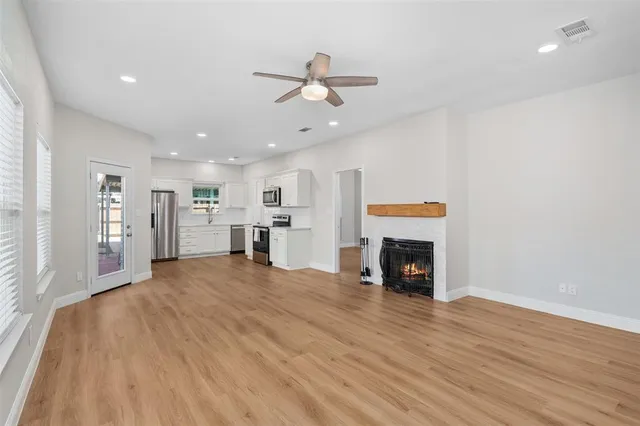 a view of an empty room with window and fire place