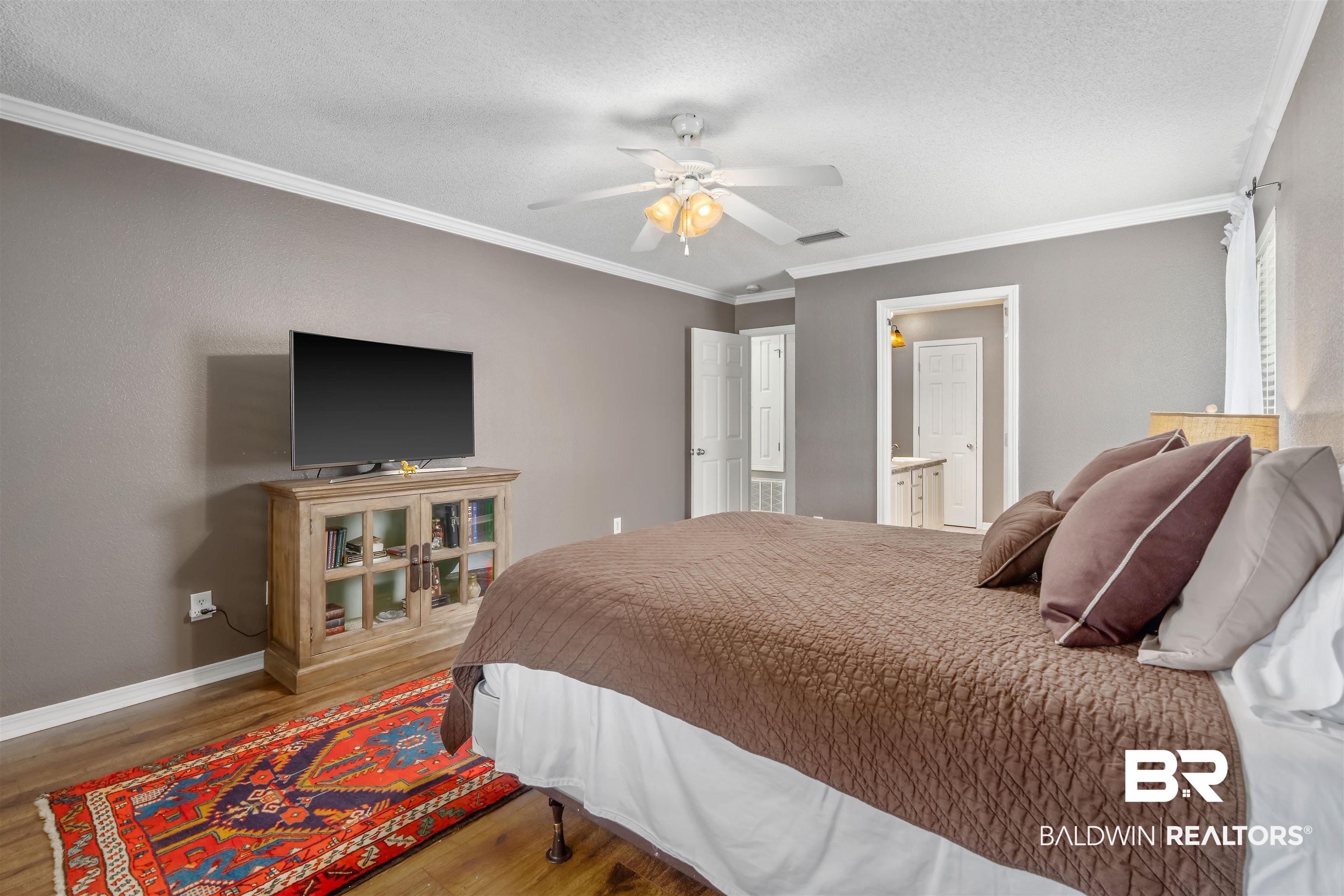 11097 Pontchartrain Loop Daphne, AL 36526 - Photo 18 of 28 Bedroom with wood finished floors, ornamental molding, a textured ceiling, ceiling fan, and connected bathroom