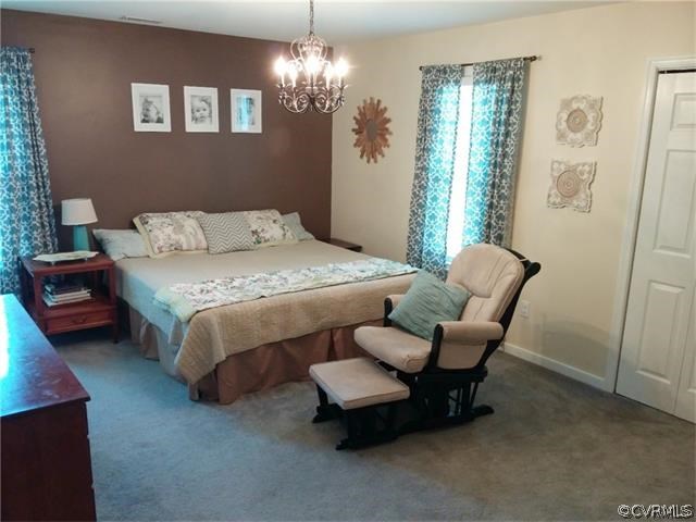 2528 London Road Henrico, VA 23233 - Photo 8 of 10 a bedroom with a bed and a chandelier