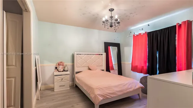 a bedroom with a bed and a chandelier