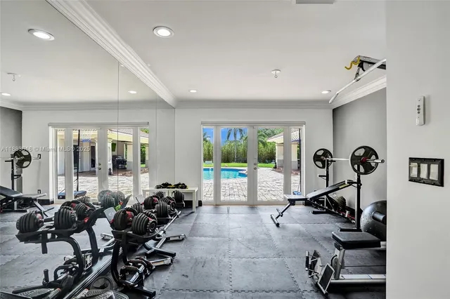 a room with gym equipment and large windows