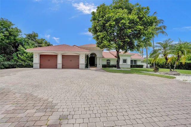 a front view of a house with a yard and trees