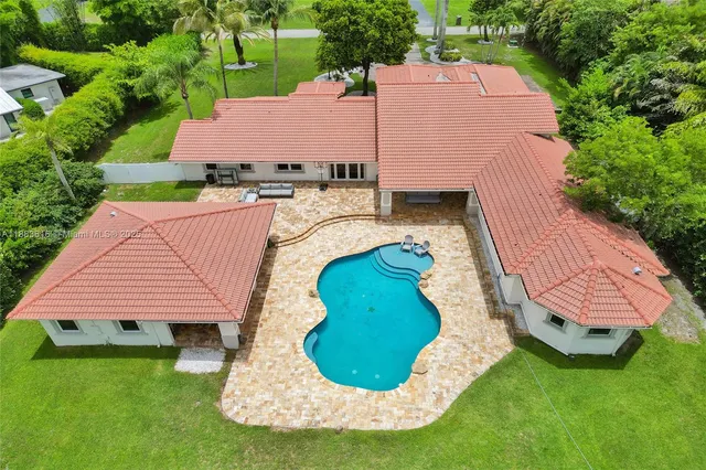 an aerial view of a house with swimming pool and deck