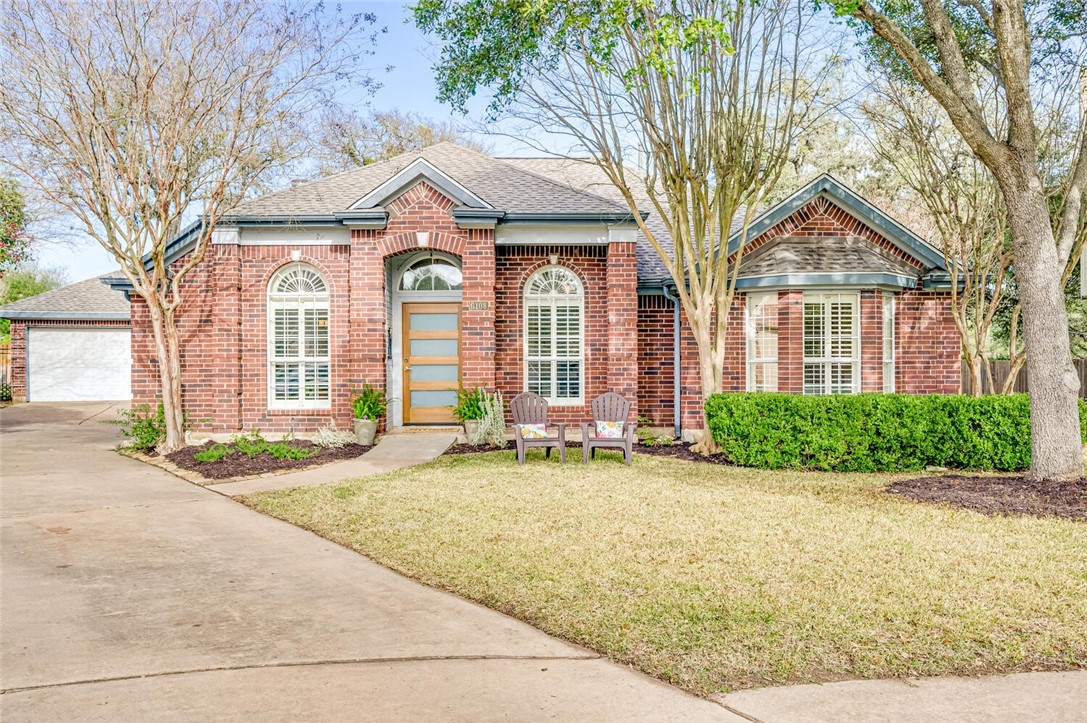 a front view of a house with yard and green space