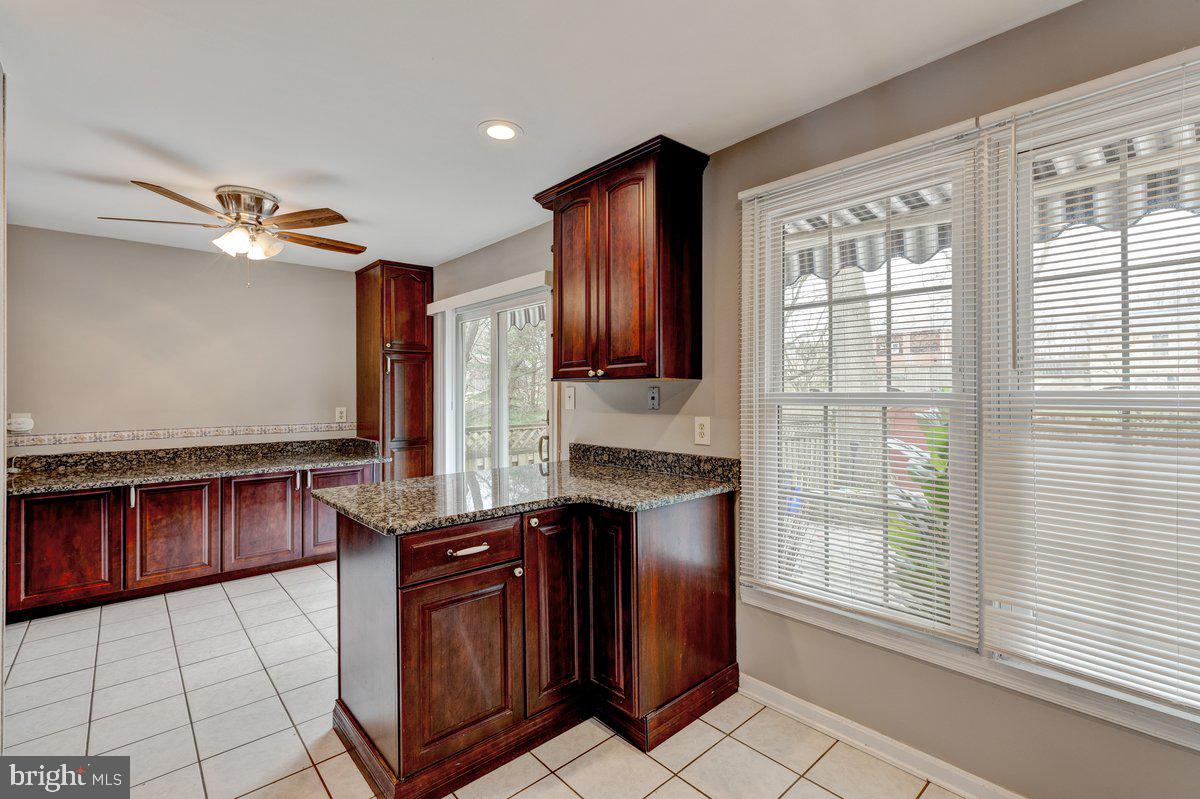 14216 Catamount Court Silver Spring, MD 20906 - Photo 5 of 30 a kitchen with granite countertop a stove top oven and cabinets