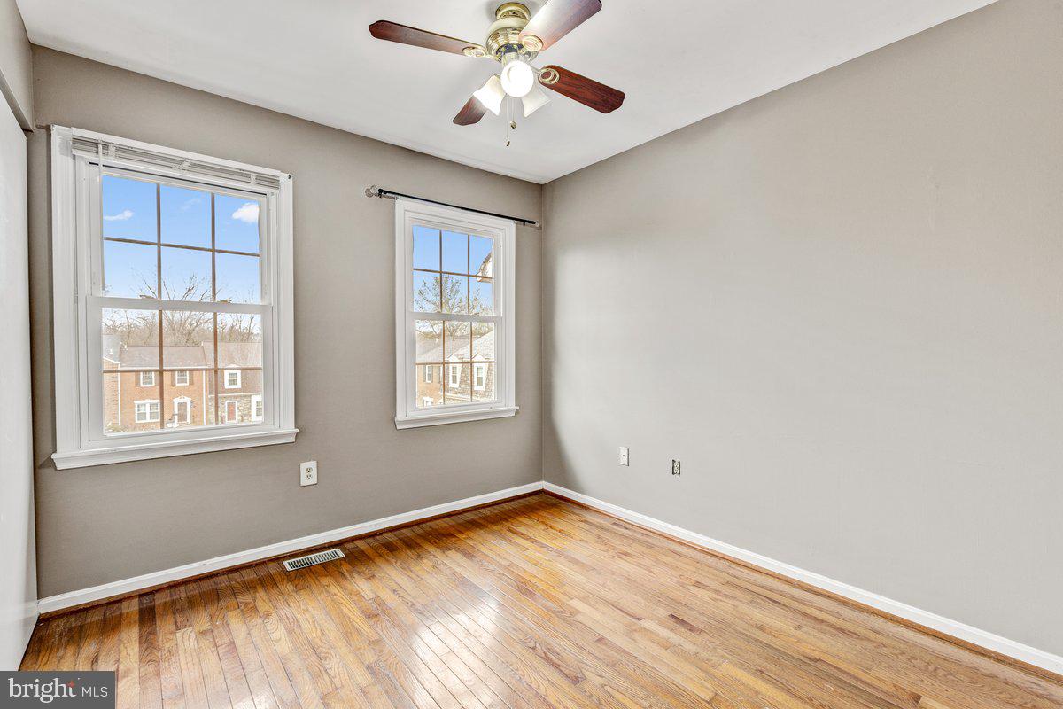 14216 Catamount Court Silver Spring, MD 20906 - Photo 9 of 30 an empty room with wooden floor chandelier fan and windows