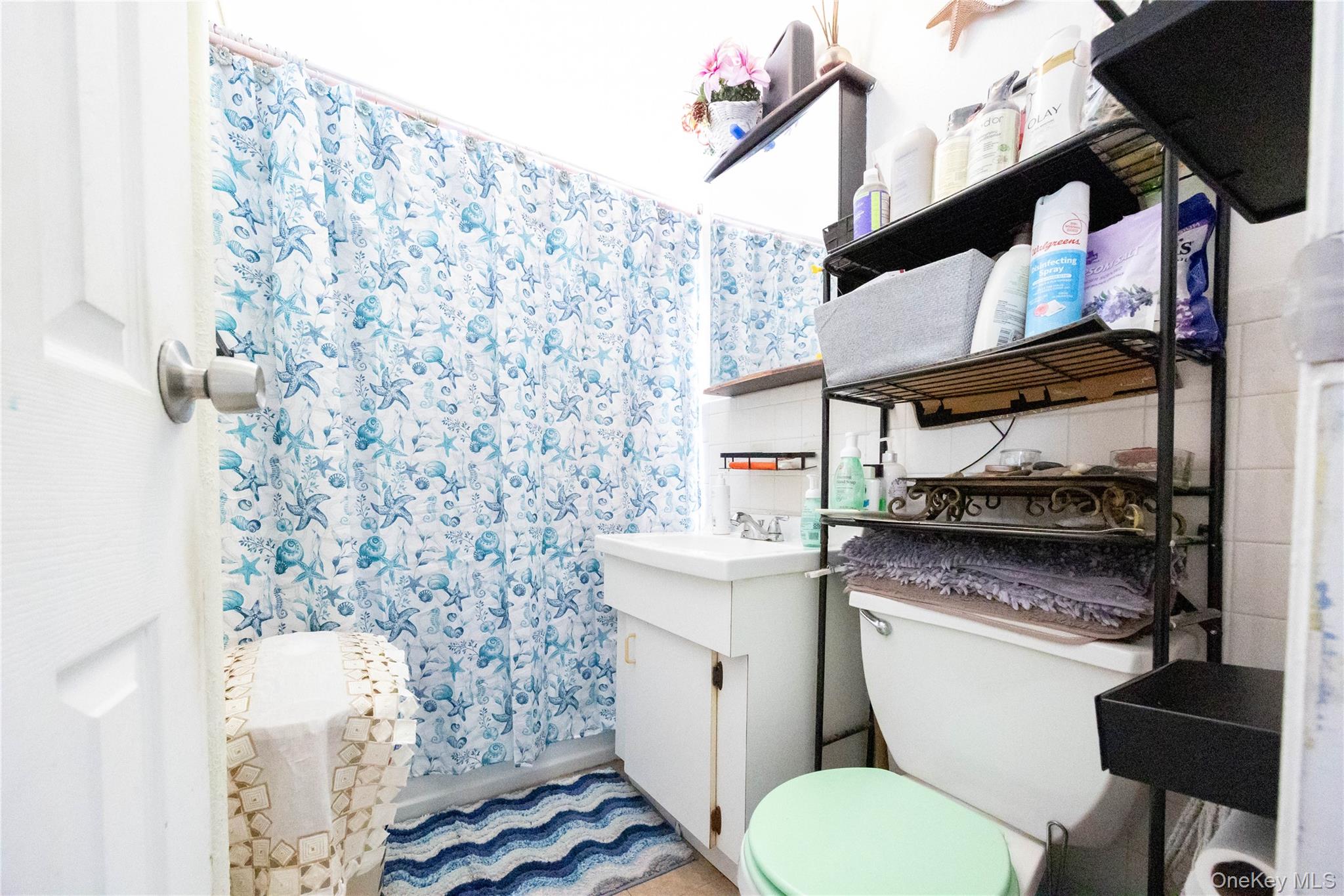 1506 Overing Street, Unit 6C Bronx, NY 10461 - Photo 9 of 16 a bathroom with a toilet and a shower curtain