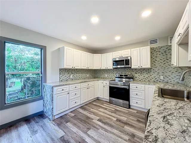 an empty room with wooden floor and a window