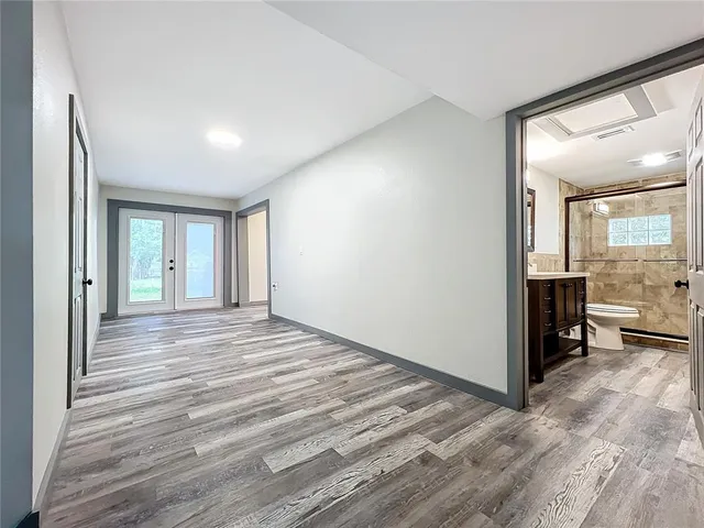 a view of a hallway with wooden floor and stairs