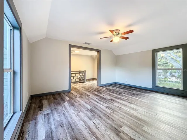 a balcony with wooden floor and trees in the back