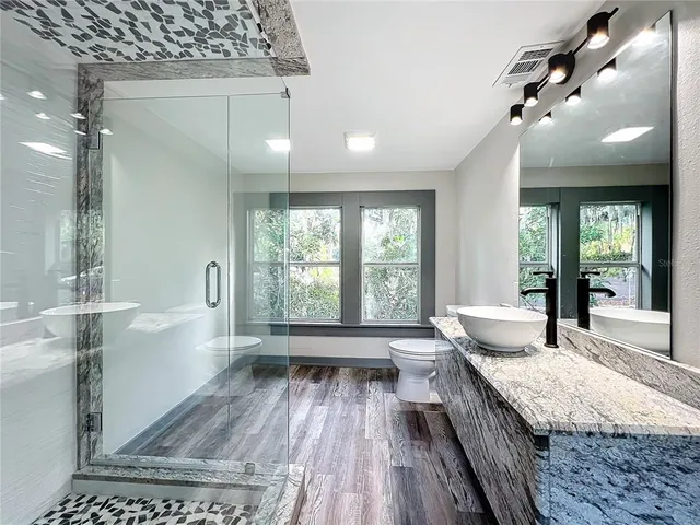 an aerial view of house with outdoor space and trees all around