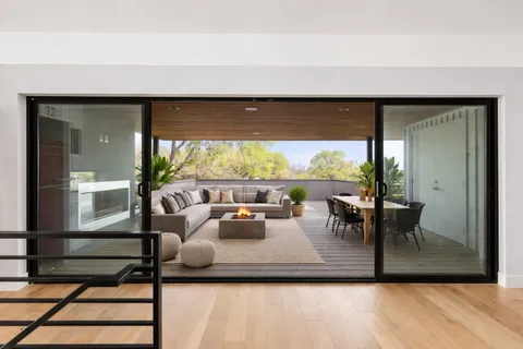 a living room with patio furniture and a potted plant