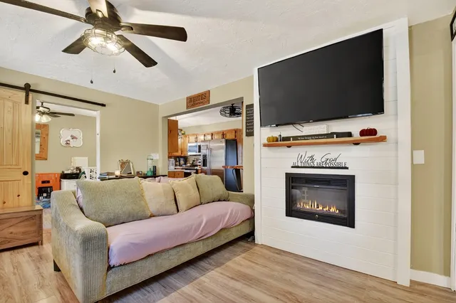 a living room with furniture a flat screen tv and a fireplace