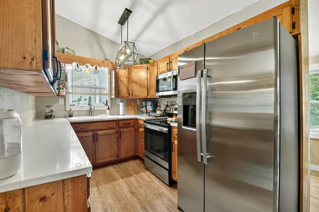 a kitchen with stainless steel appliances granite countertop a refrigerator and a sink