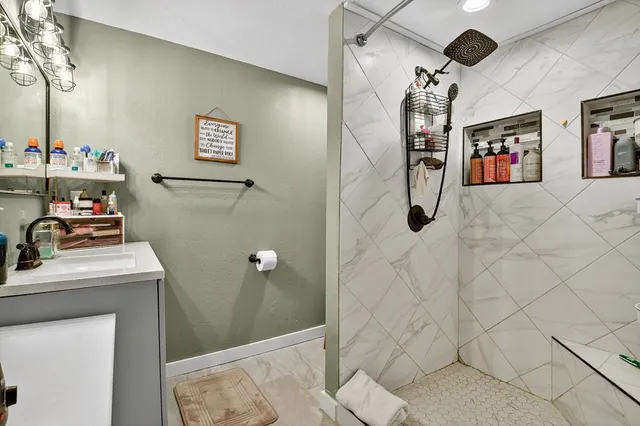 a bathroom with a sink a toilet and shower