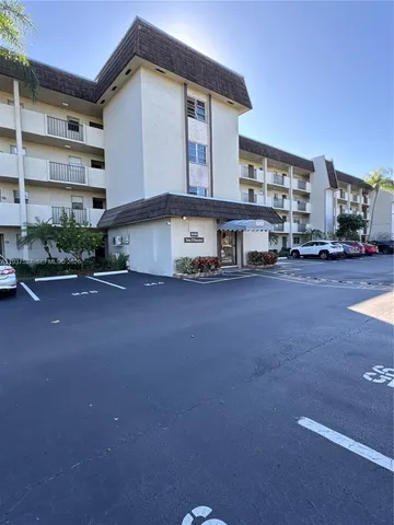 a view of a building with cars parked in front of it