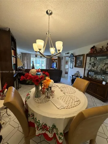 a view of a dining room with furniture and a chandelier