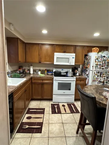 a kitchen with stainless steel appliances kitchen island granite countertop a stove and a sink