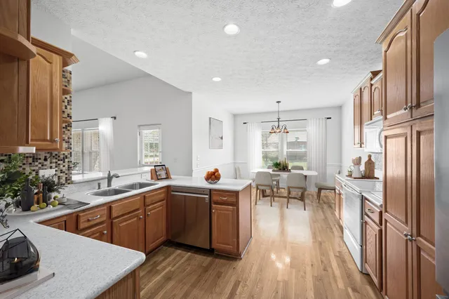 a kitchen with stainless steel appliances granite countertop a sink stove and wooden floor
